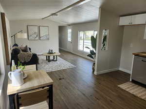 Living room with baseboards and dark wood-style flooring