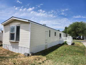 View of side of home featuring a yard