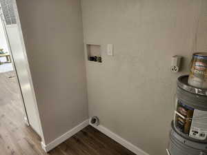 Laundry room featuring a textured wall, wood finished floors, and a heating unit
