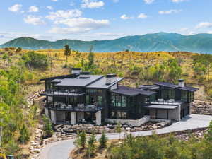 Back of house with a standing seam roof, a garage, a metal roof, and a patio