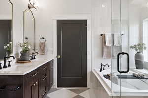 Builders Model for example purposes only. Bathroom featuring double vanity, a garden tub, and a stall shower