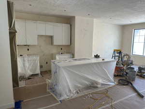 Laundry room with a textured ceiling
