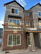 Back of property featuring brick siding and a patio area