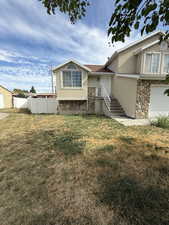 View of front of house featuring stone siding, stucco siding, and a garage