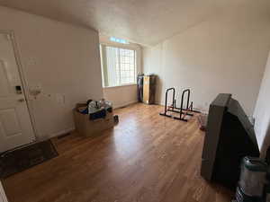 Unfurnished living room with wood finished floors and a textured ceiling