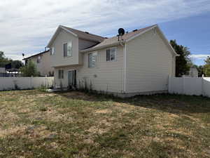 Rear view of house featuring a fenced backyard
