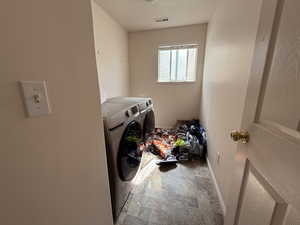 Laundry room with washer and clothes dryer and baseboards