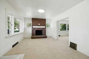 Unfurnished living room featuring carpet floors and a fireplace