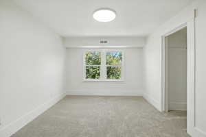Unfurnished bedroom featuring light colored carpet and baseboards