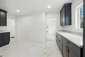 Bar area with plenty of natural light, light marble finish floors, recessed lighting, and light stone counters