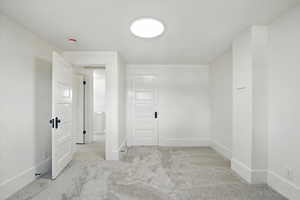 Spare room with light colored carpet and baseboards