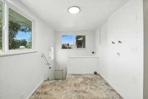 Laundry area with stone finish flooring and washer hookup