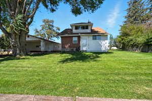 Back of house featuring a yard and a chimney