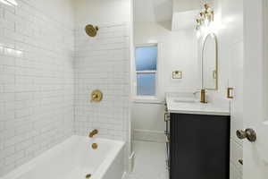 Full bathroom with shower / bath combination, vanity, and light tile patterned floors