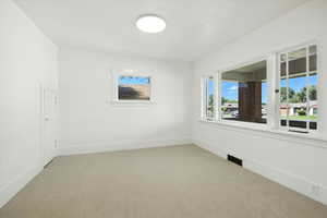 Carpeted empty room featuring baseboards