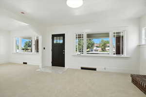 Carpeted foyer with baseboards