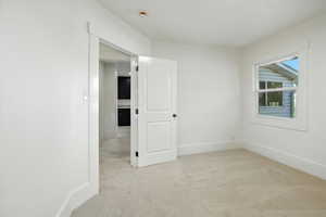 Empty room featuring carpet and baseboards