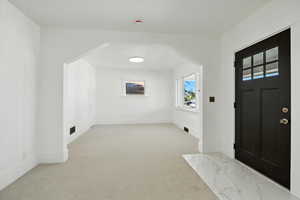 Foyer featuring light carpet and baseboards