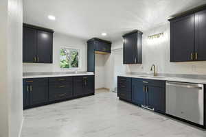 Kitchen featuring dishwasher, light marble finish floors, recessed lighting, and light stone countertops