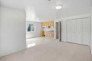 Unfurnished living room with light colored carpet and baseboards