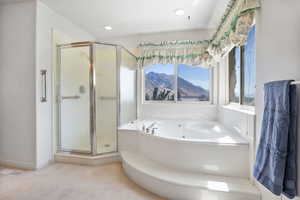 Full bath featuring a tub with jets, a stall shower, a mountain view, and recessed lighting