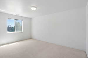 Carpeted spare room featuring baseboards