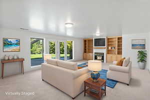 Living area featuring light carpet, a glass covered fireplace, and built in shelves