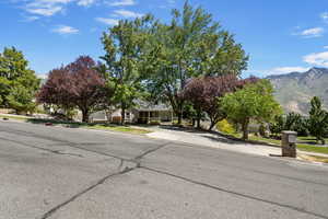 View of asphalt road with sidewalks, curbs, and a mountain view