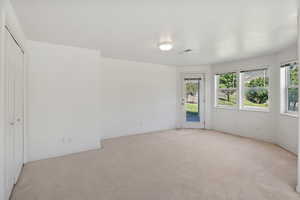 Unfurnished bedroom with light colored carpet, access to exterior, and a closet