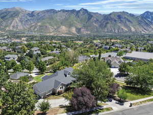 Aerial view of property and surrounding area featuring a mountainous background and nearby suburban area