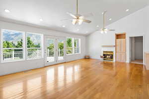 Unfurnished living room featuring recessed lighting, light wood finished floors, a tiled fireplace, high vaulted ceiling, and ceiling fan