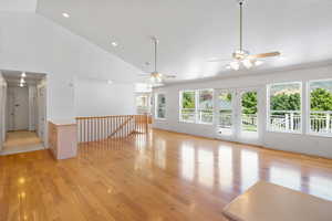 Unfurnished living room with light wood-type flooring, high vaulted ceiling, recessed lighting, and ceiling fan