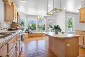 Kitchen with light countertops, light brown cabinets, light wood-style flooring, and recessed lighting