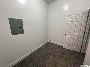 Unfurnished room with dark colored carpet and electric panel