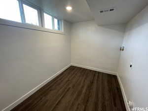 Basement featuring baseboards and dark wood-style flooring