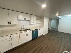 Kitchen with white cabinets, open shelves, a textured ceiling, dishwashing machine, and dark wood finished floors