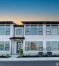 View of front of home featuring brick siding and stucco siding