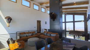 Upstairs Loft with beam ceiling, healthy amount of natural light, a ceiling fan, and a towering ceiling