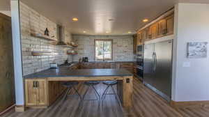 Kitchen with open shelves, backsplash, brown cabinets, built in appliances, and a peninsula