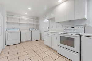 Kitchen with white range with electric stovetop, white cabinets, washer / clothes dryer, light countertops, and recessed lighting