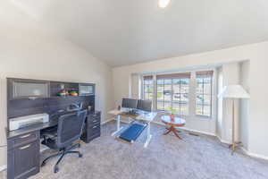 Home office featuring carpet floors and vaulted ceiling