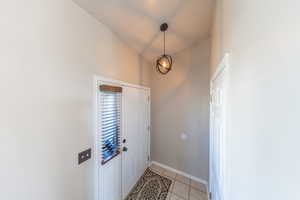 Foyer with light tile patterned floors and baseboards