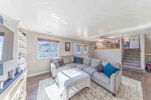 Living area featuring wood finished floors, stairway, and ceiling fan