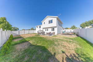 Rear view of property featuring a patio area and a fenced backyard