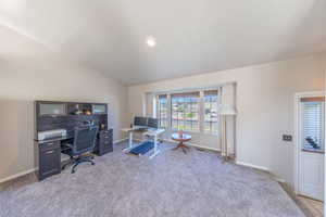 Home office featuring light carpet and vaulted ceiling