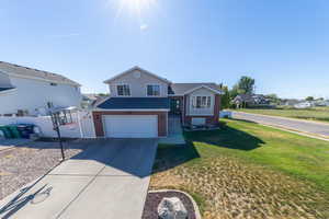 View of front of house featuring an attached garage, concrete driveway, and brick siding