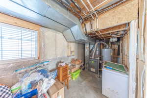 Basement with white refrigerator and heating unit