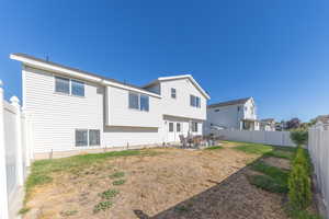 Rear view of house featuring a patio area and a fenced backyard