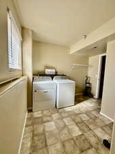 Laundry room featuring independent washer and dryer and baseboards