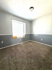 Spare room featuring carpet floors and a textured ceiling
